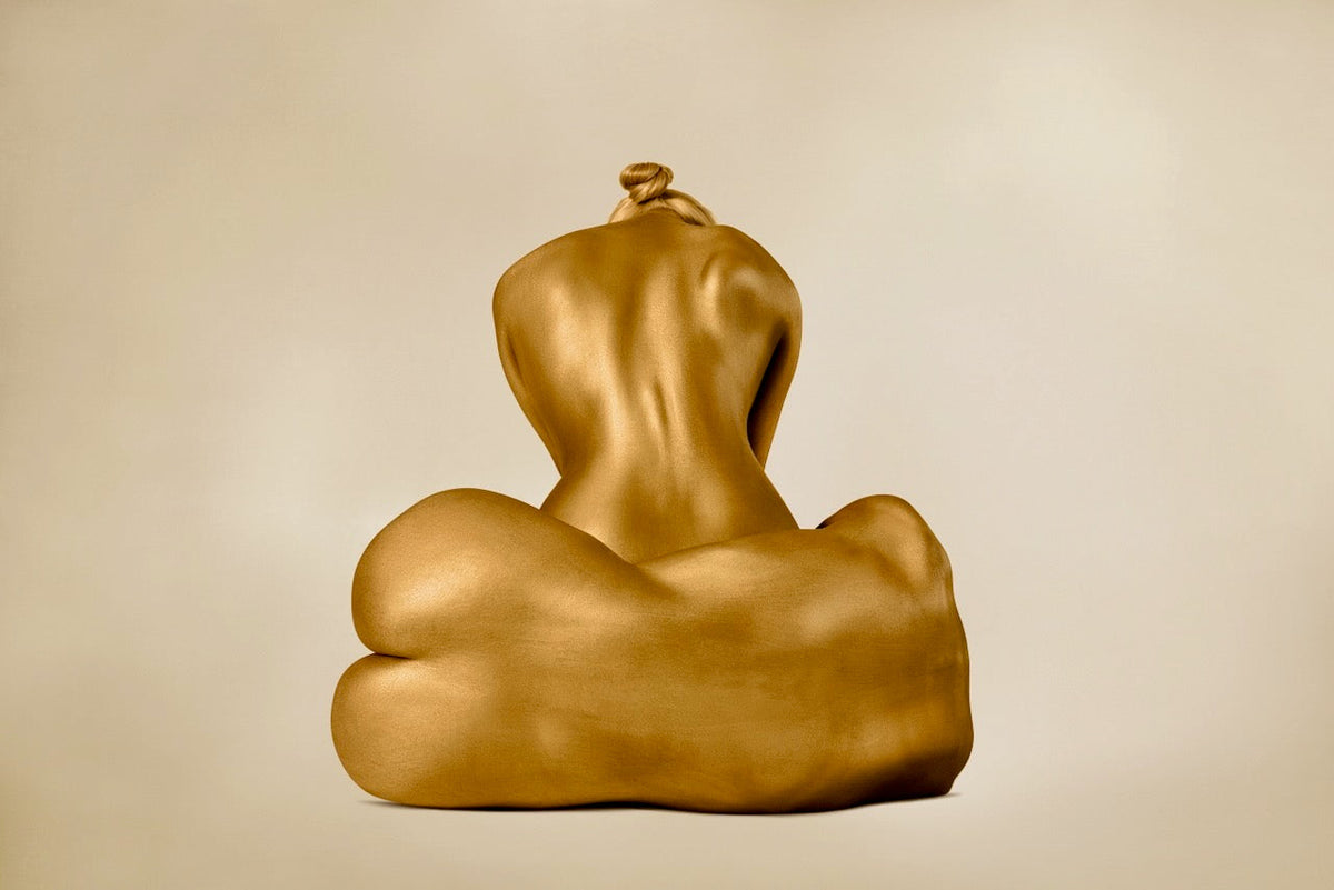 Sculptural fine art photography of a golden seated human form with organic curves by Zack Zublena, luxury wall art.