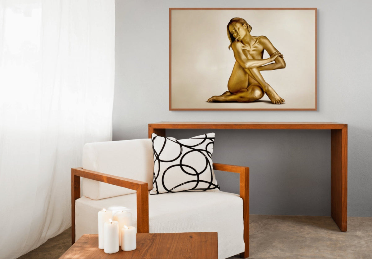 Framed gold-painted female figure by Zack Zublena displayed in an elegant minimalist interior with warm wood furnishings.