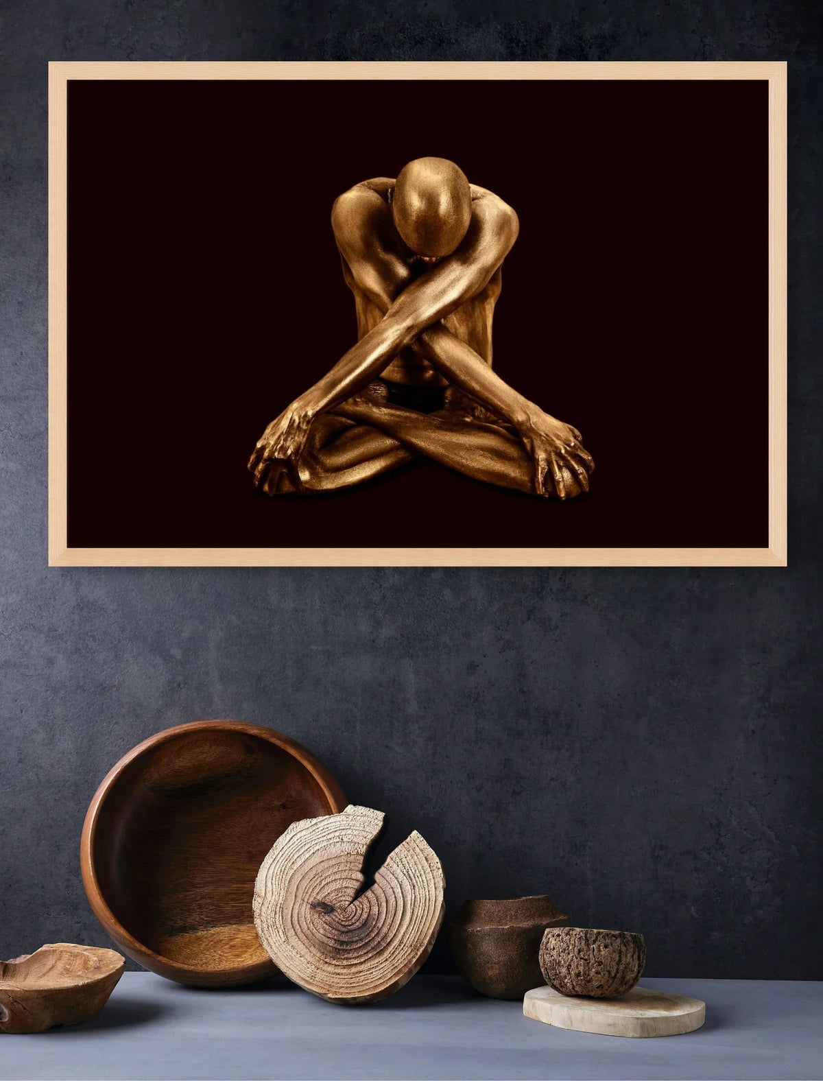 Framed golden sculptural fine art photography displayed on a dark textured wall above rustic wooden bowls and decor by Zack Zublena.
