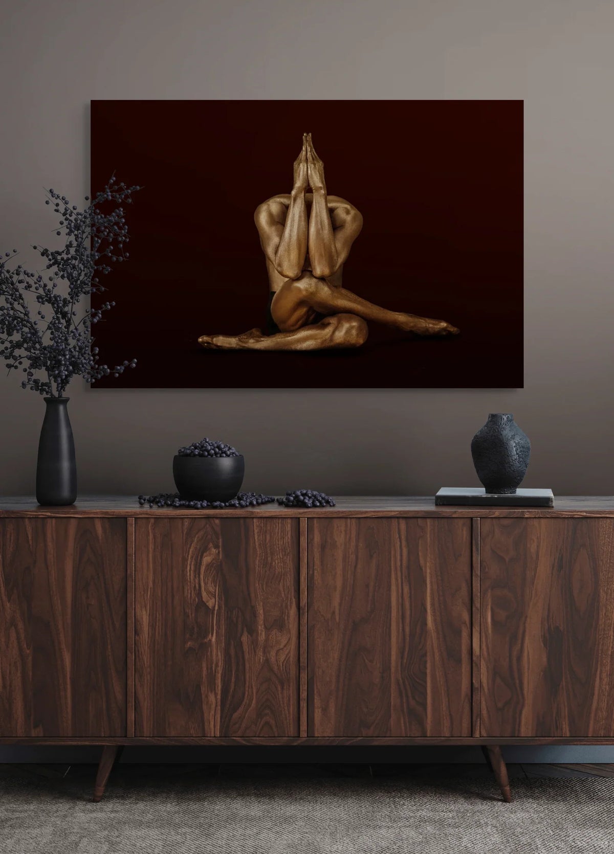 Gold-painted figure in a seated yoga pose with joined hands raised, fine art photograph by Zack Zublena above a walnut sideboard in a Boston interior