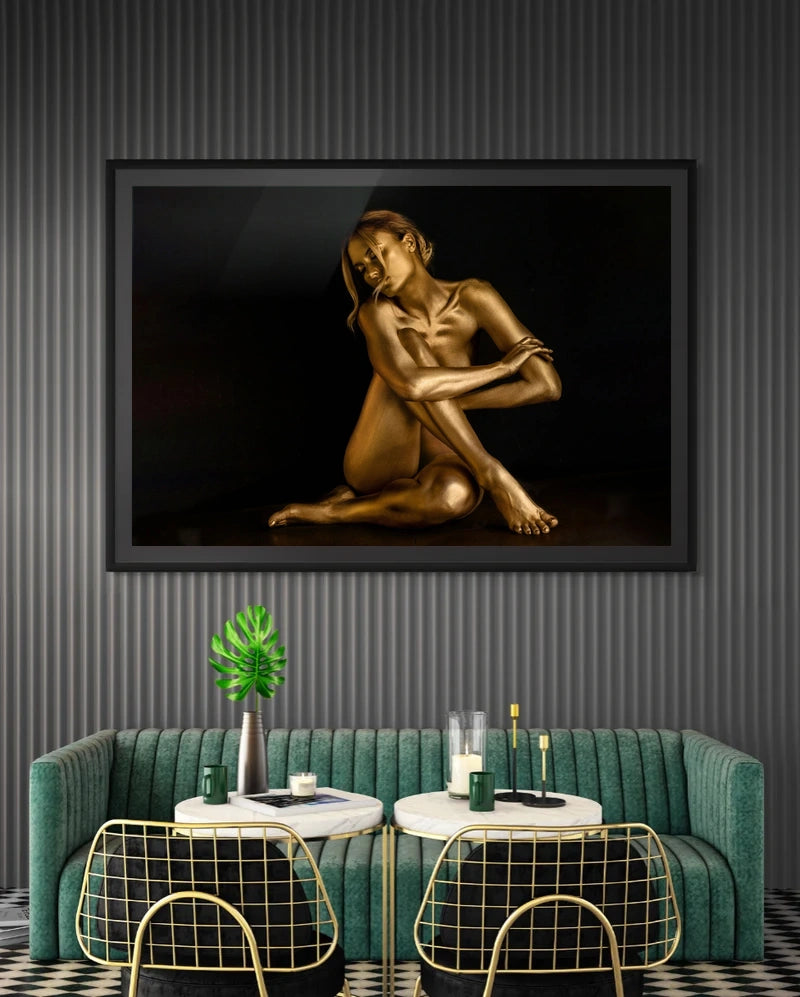 Moonlit Reverie II – Embrace by Zack Zublena: gold fine art photograph of a seated golden figure in a black frame above a green velvet sofa in a modern lounge