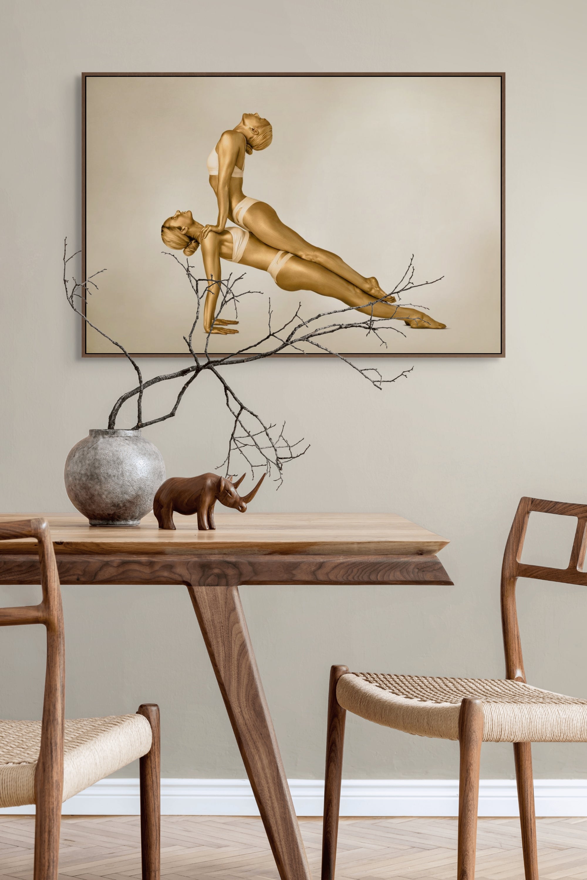Fine art photography of two golden-painted female figures in a synchronized yoga pose, captured as contemporary wall art for luxury interiors, yoga studios, and modern wellness spaces.
