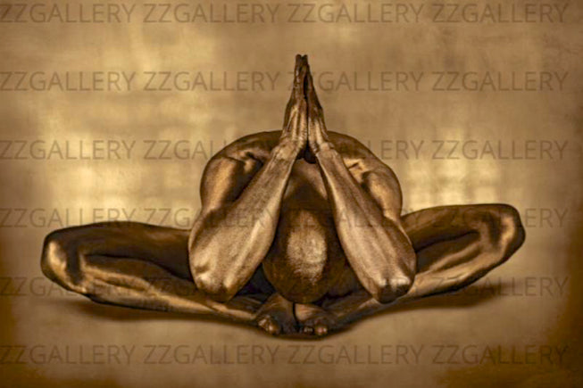 Golden-painted male figure in a meditative yoga pose with palms pressed together, fine art photography symbolizing serenity, reverence, and spiritual strength.
