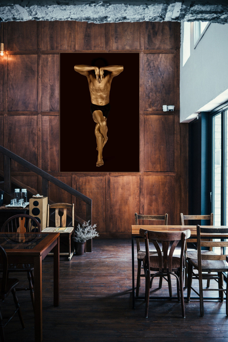 Golden-painted male figure in a striking yoga balance pose, arms folded over the head with legs crossed, captured in Zack Zublena’s conceptual fine art photography.