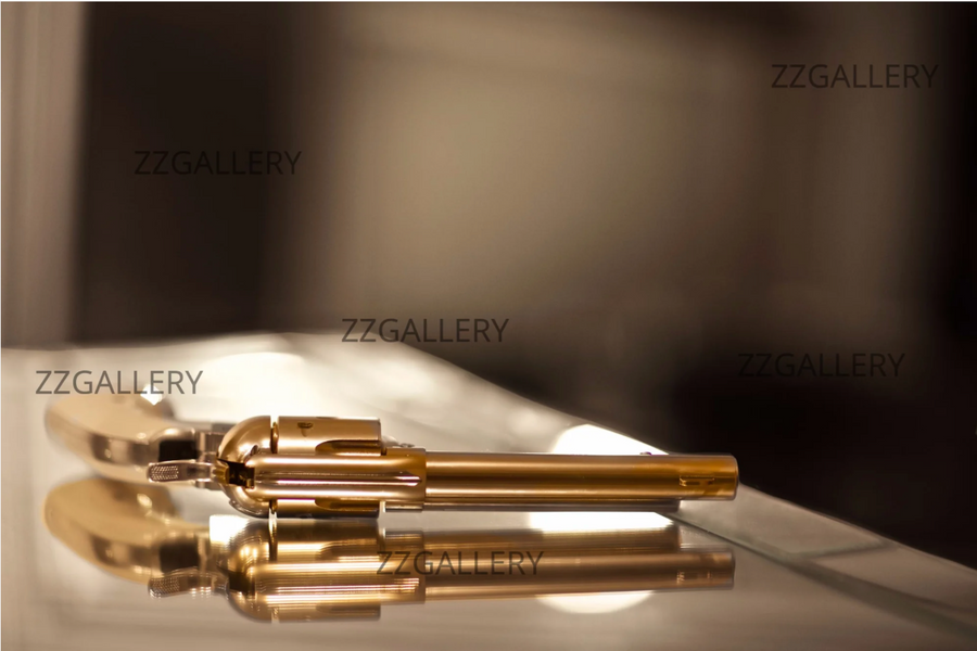 Golden revolver luxury wall art by Zack Zublena displayed in an elegant living room interior with chandelier and classic decor.