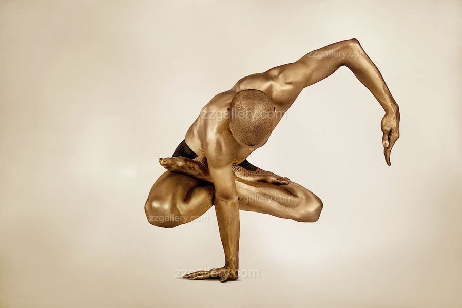 Golden-painted male figure performing an elegant one-arm balance pose with sculptural precision, highlighting strength, focus, and harmony — contemporary fine art photography by Zack Zublena, perfect for luxury interiors, yoga studios, spas, and wellness spaces.