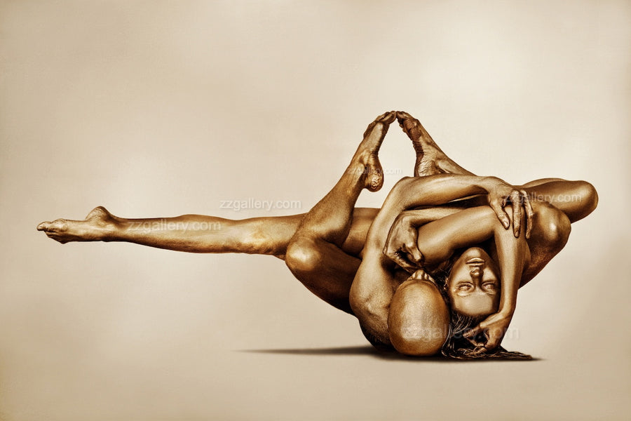 Golden-painted couple in an intertwined acrobatic yoga pose, captured as fine art wall photography and displayed in a modern outdoor lounge with mountain views.