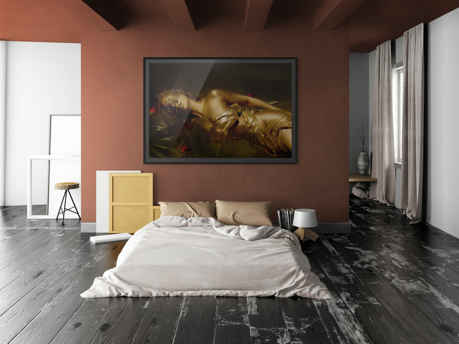 Luxurious bedroom interior with a large framed golden artwork above a low bed. The dark wood floor contrasts with terracotta walls, creating an elegant, artistic atmosphere.