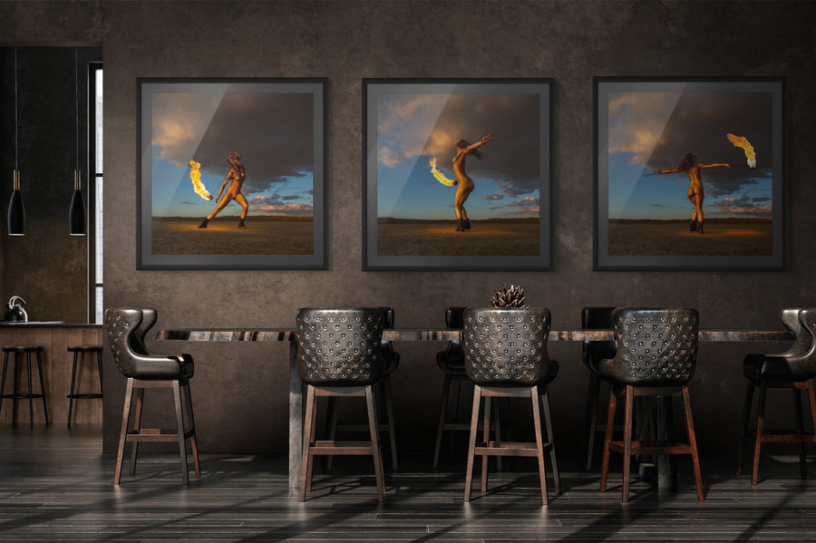 Modern interior with a triptych of fine art photography from the Skyfall Flames series, showing a golden-painted figure performing with fire under a dramatic desert sky at sunset.