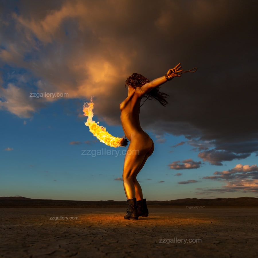 Framed fine art photograph of a gold-painted woman performing with fire in a desert at sunset, displayed on a modern wooden wall, from the Skyfall Flames VI – Phoenix Ascent series.