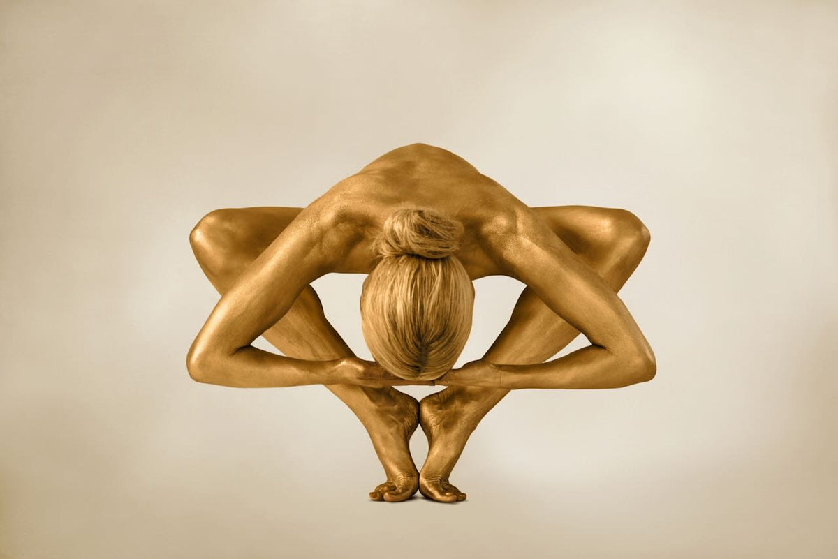 Supernova Zen fine art photography by Zack Zublena featuring a gold-painted figure in a complex symmetric yoga pose