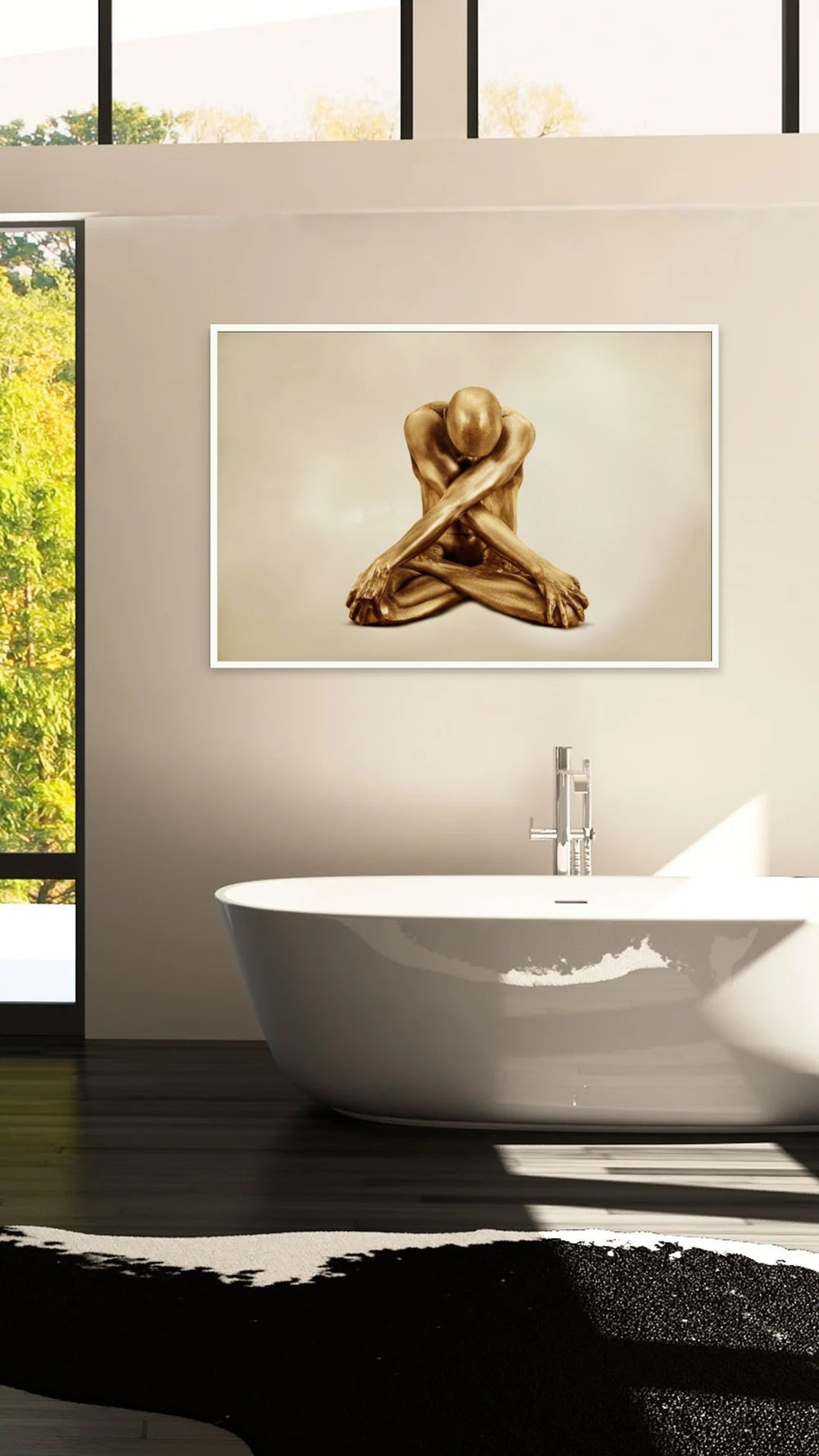 Zack Zublena gold fine art photograph of a seated golden figure in a white frame above a freestanding bathtub in a bright modern bathroom.