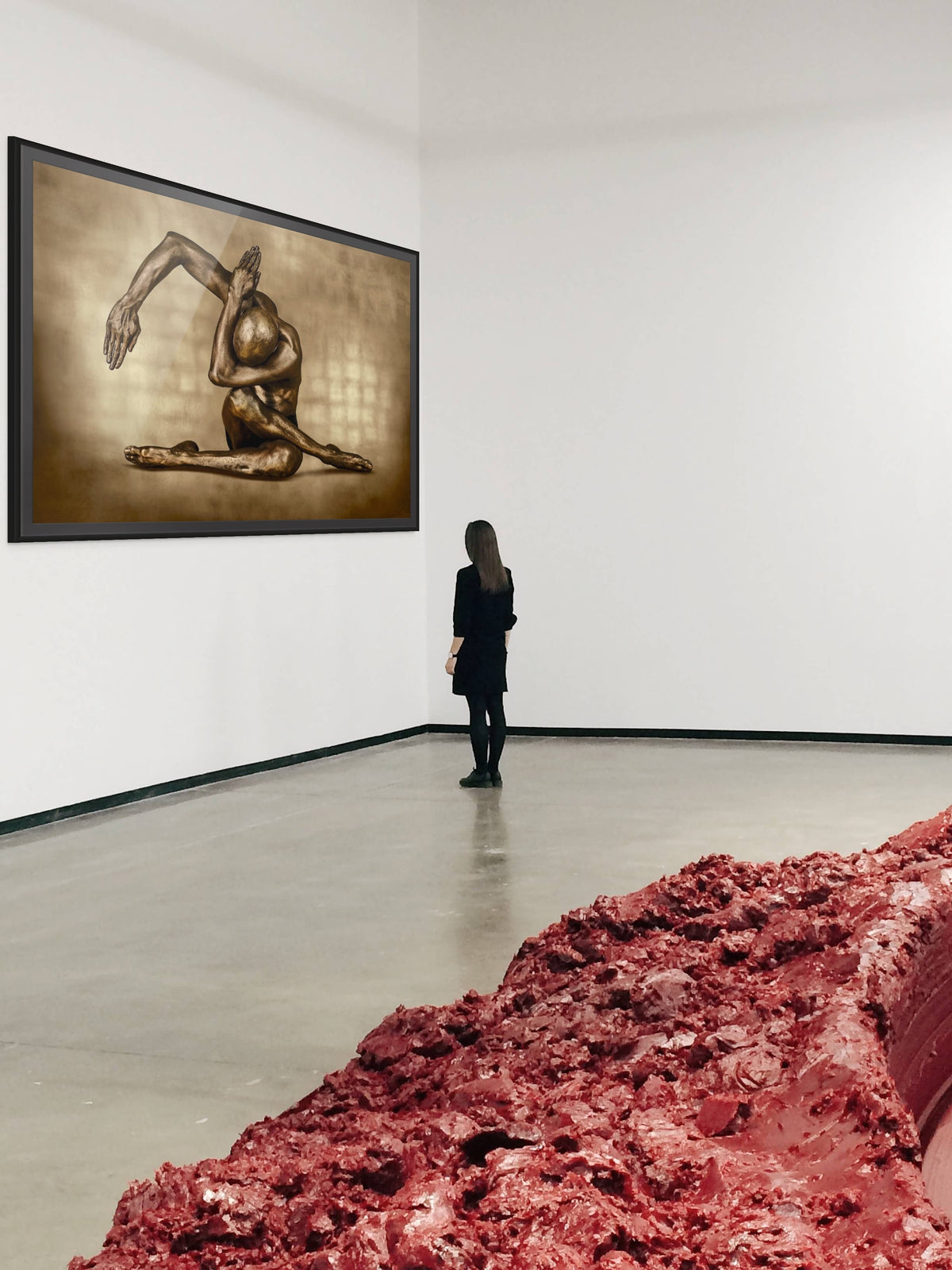 Gold-painted figure in a sculptural yoga pose by Zack Zublena, large-format fine art photography in a white contemporary gallery with a visitor looking on, Aspen art scene