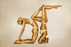 Golden nude yogi duo in acrobatic yoga pose, luxury fine art photography, museum-quality golden body art for spa, hotel, and LGBTQ inclusive decor.