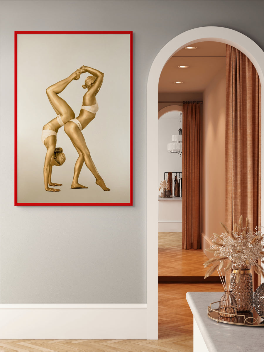 Golden-painted duo in an acrobatic yoga pose, captured in a contemporary fine art photograph. Perfect wall décor for luxury interiors, yoga studios, wellness spaces, and modern art collectors.