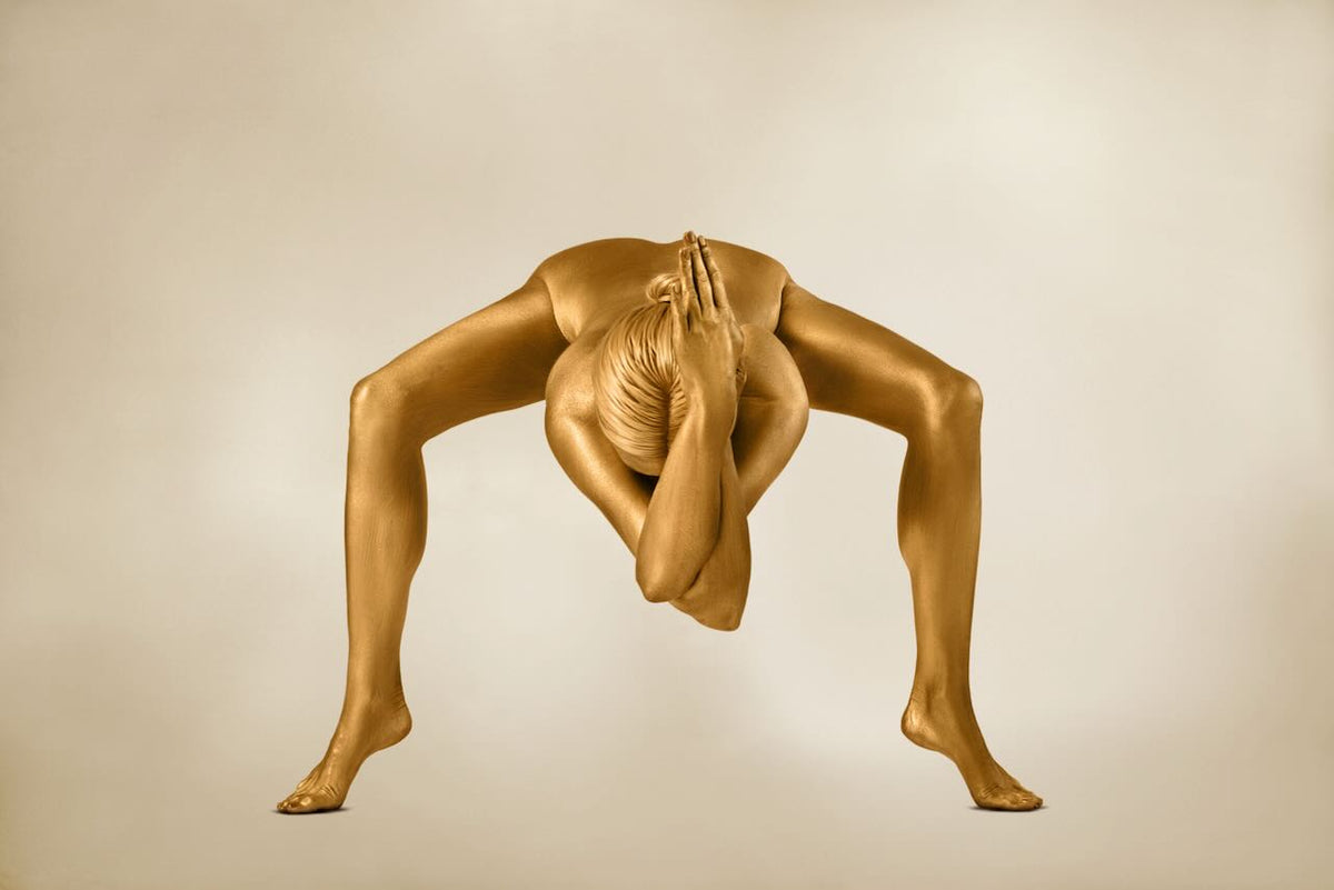 Genesis Zen fine art photography by Zack Zublena featuring a gold-painted figure in an arched meditative pose