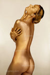 gold-painted nude woman in elegant pose, fine art photography symbolizing feminine power, divine beauty, and golden ascension