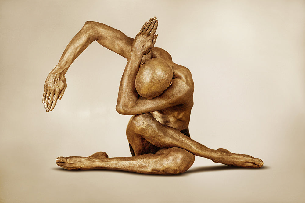 Gold-painted man in expressive yoga pose with arms curved overhead, fine art wall decor for modern spiritual or yoga interiors