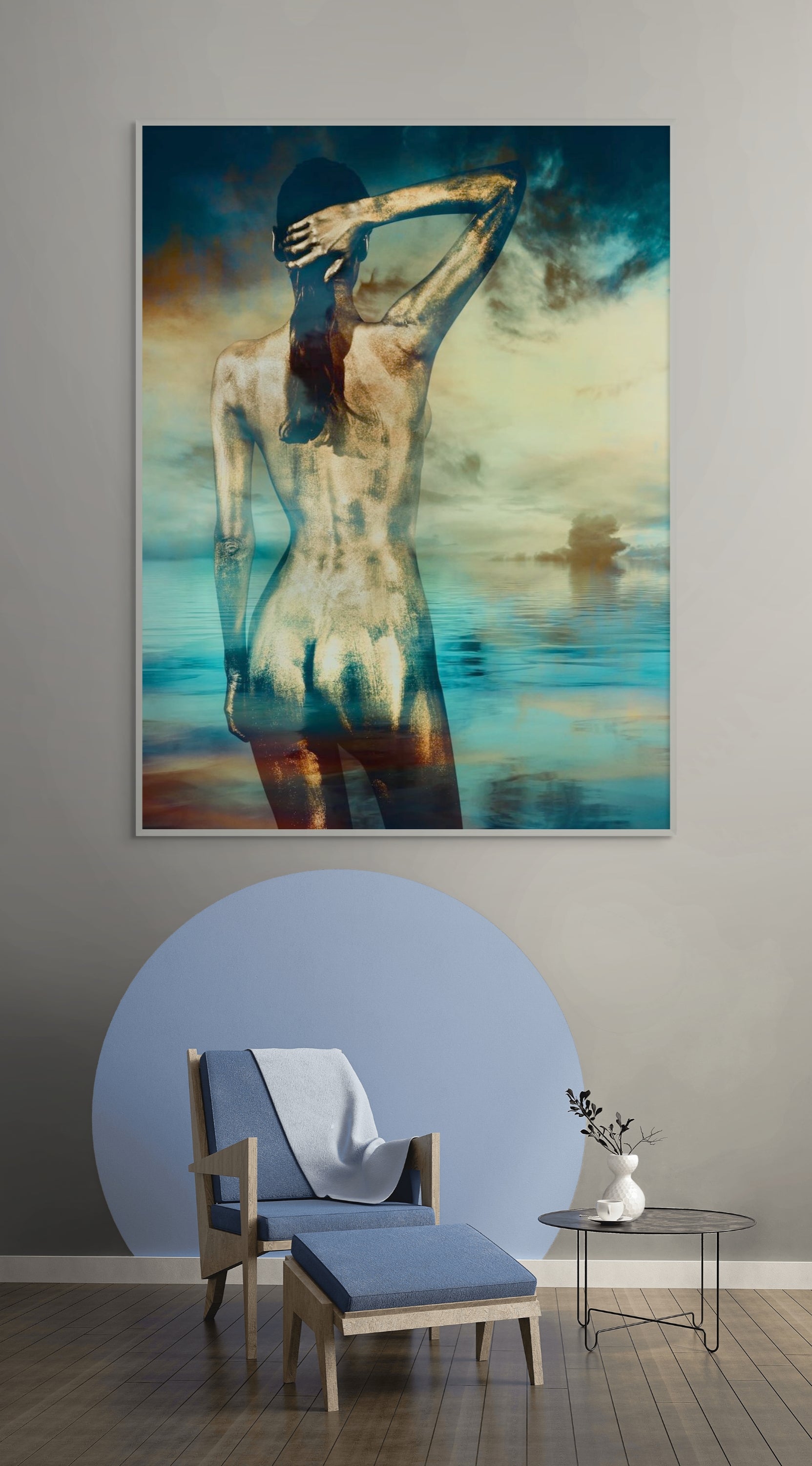 Golden-painted silhouette figure facing the ocean, contemporary fine art print displayed above a modern chair in a stylish living room.