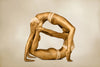 Golden acrobatic female duo in balance pose, luxury fine art photography for hotel, spa, wellness, and contemporary interiors