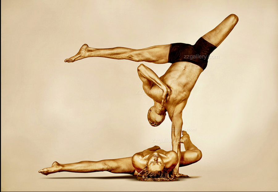 Golden-painted couple performing an acro-yoga balance pose, photographed by Zack Zublena — fine art wall decor celebrating strength, unity, and harmony, ideal for yoga studios, wellness spaces, luxury resorts, and contemporary interiors.