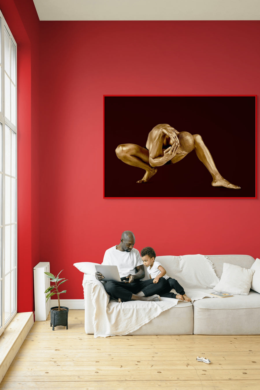 Gold-painted male figure in a seated forward pose with hands clasping head, displayed against a deep dark background. Contemporary fine art photography by Zack Zublena.