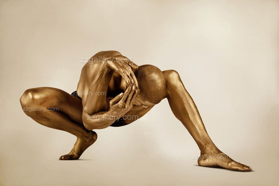 Golden-painted male figure in a crouched yoga pose, head lowered and hands framing the skull, embodying the Wheel of Life in Zack Zublena’s avant-garde quantum fine art photography.