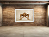 Golden-painted nude figure in a deep squat pose, arms crossing and gripping ankles, representing strength, meditation, and edgy conceptual fine art photography.
