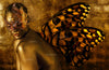 Golden-painted woman wearing an ornate masquerade mask with radiant butterfly wings, blending mystery, transformation, and divine feminine beauty in fine art photography by Zack Zublena.