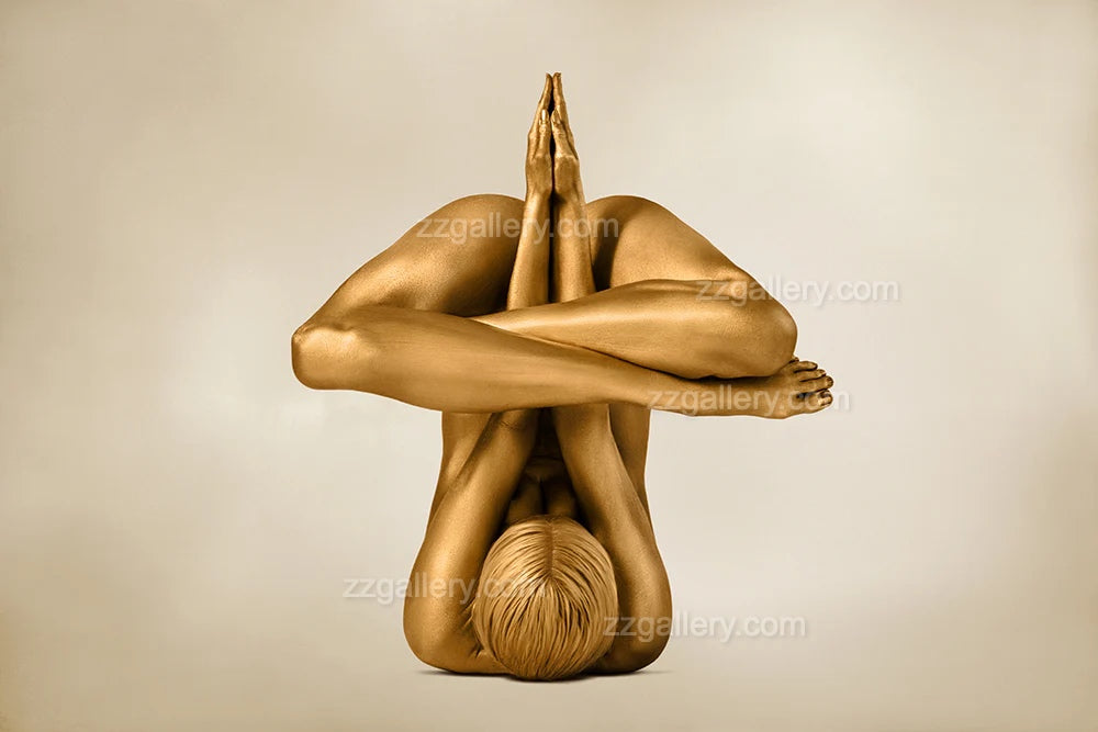 Golden-painted figure in a rocket-like yoga pose with legs crossed upward and hands pressed together — fine art photography by Zack Zublena, contemporary sculptural wall art for interiors, spas, and collectors.