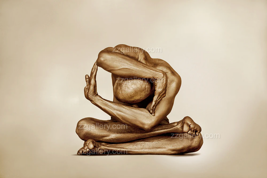 Golden nude figure in a circular yoga pose, painted in shimmering gold, displayed above a modern sofa with orange accents.