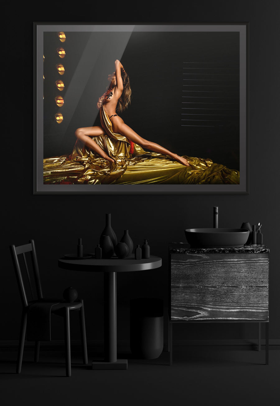 Golden-painted woman draped in flowing fabric on stage, luxury fine art photography with dramatic lighting and glamorous elegance.