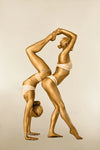 Gold-painted female acrobatic duo in a strength pose, contemporary fine art photography for luxury hotels, spas, wellness retreats, and collectors.