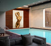 Golden-painted nude woman posed with elegance, displayed as fine art photography by Zack Zublena above a luxury indoor pool, blending sensuality, grace, and contemporary sophistication.