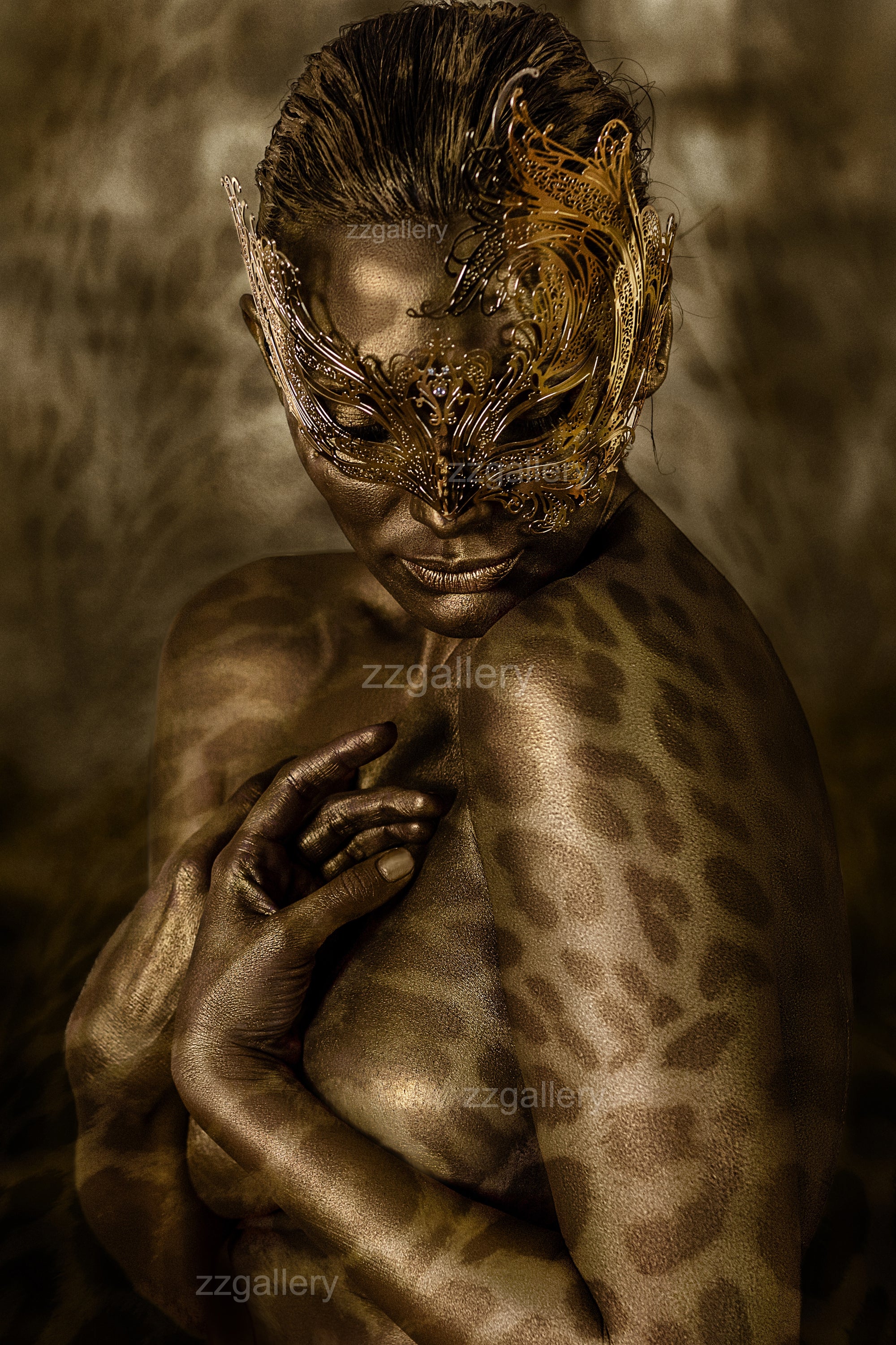 Close-up fine art photograph of a golden-painted face with leopard patterns and ornate golden mask, symbolizing primal beauty and feminine power.