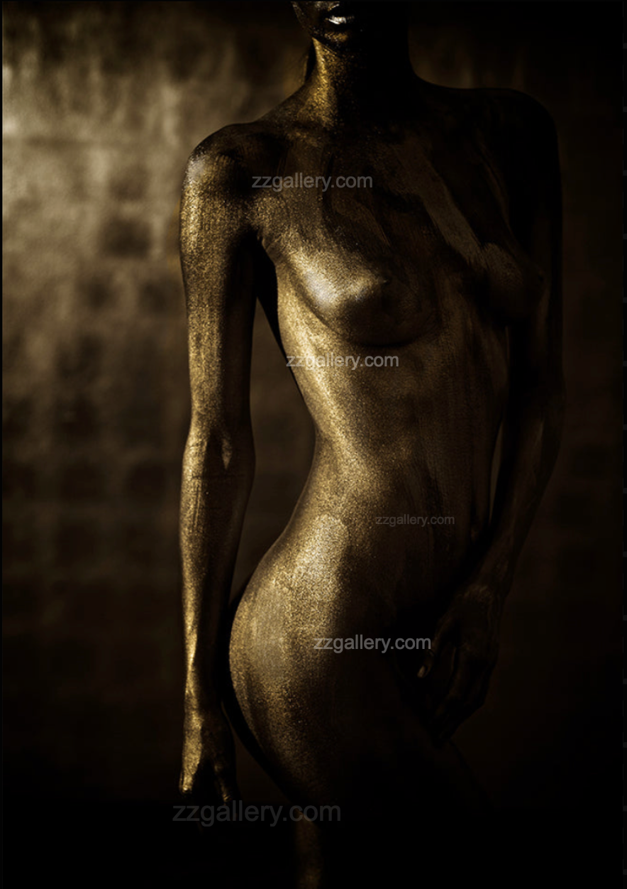 Golden nude female body art photograph displayed on a textured stone wall in a rustic modern living room, paired with a bright orange chair and cozy decor.