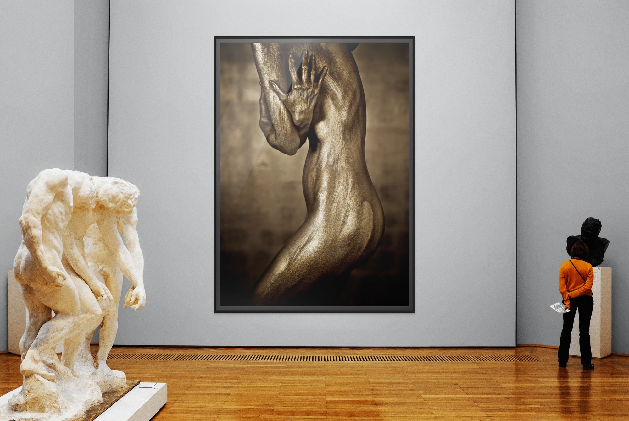 Golden female side fine art photograph with protective hand gesture displayed in a museum gallery – contemporary figurative wall art