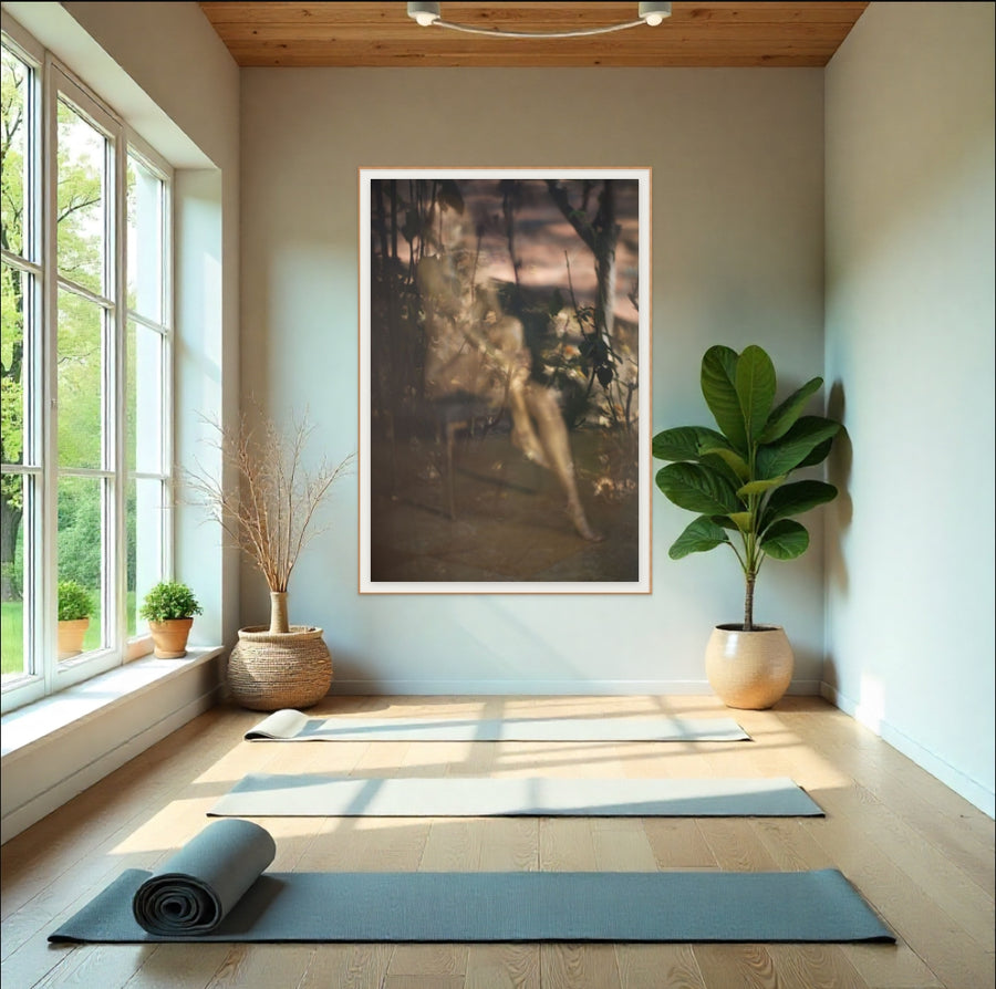 Golden-painted feminine figure in soft-focus fine art photograph, framed and displayed in a serene yoga studio with natural light and plants.