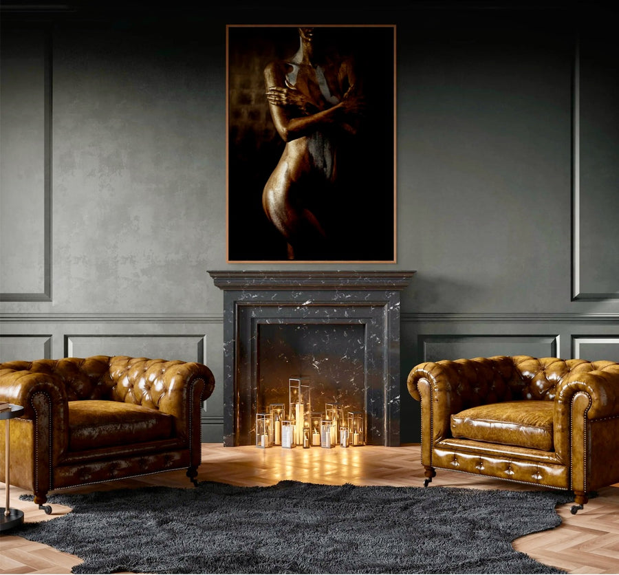 Golden fine art photograph of a sculptural silhouette painted in shimmering gold and silver tones, displayed above a black marble fireplace in a luxury interior.