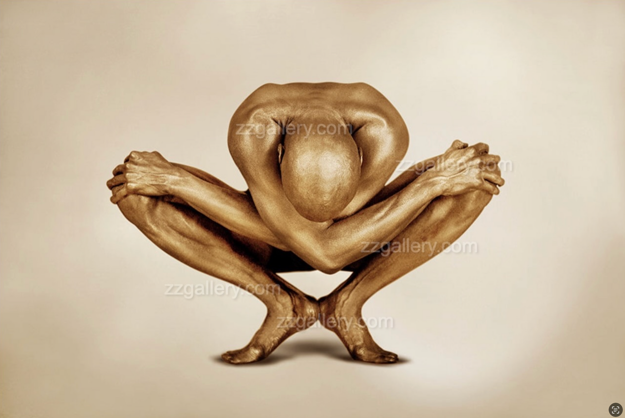 Golden-painted male in deep yoga squat pose against beige background by Zack Zublena