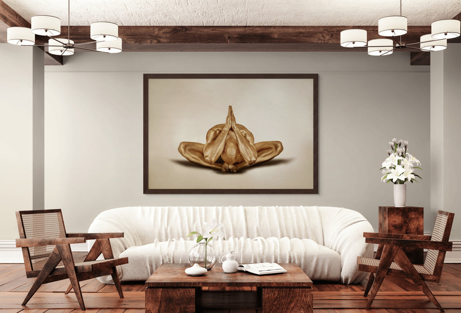 Golden-painted male figure in a meditative yoga pose with hands pressed together, displayed as fine art wall décor in a modern living room interior.
