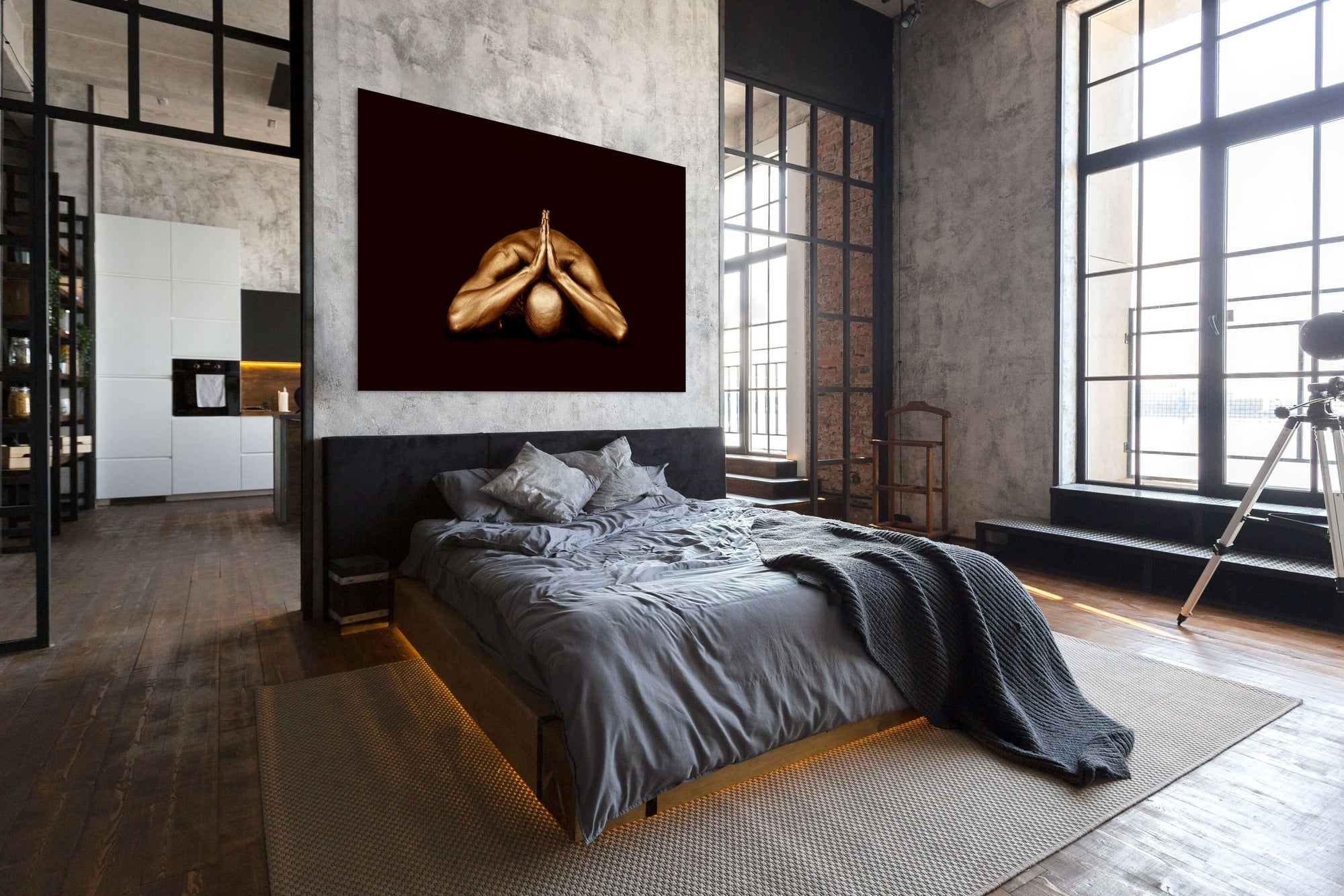 Gold-painted male figure with folded hands in a child’s pose, contemporary fine art wall decor displayed in a modern bedroom interior.