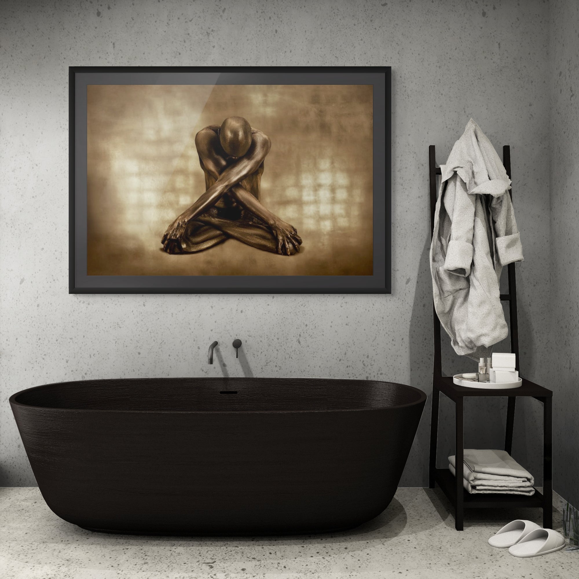 Golden-painted male figure seated with crossed arms in a yoga pose, fine art wall art displayed above a modern black bathtub in a minimalist bathroom interior.