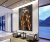 Framed golden fine art photograph of a muscular male torso with metallic body paint, displayed in a modern lobby with armchairs, table, and large windows overlooking mountains.