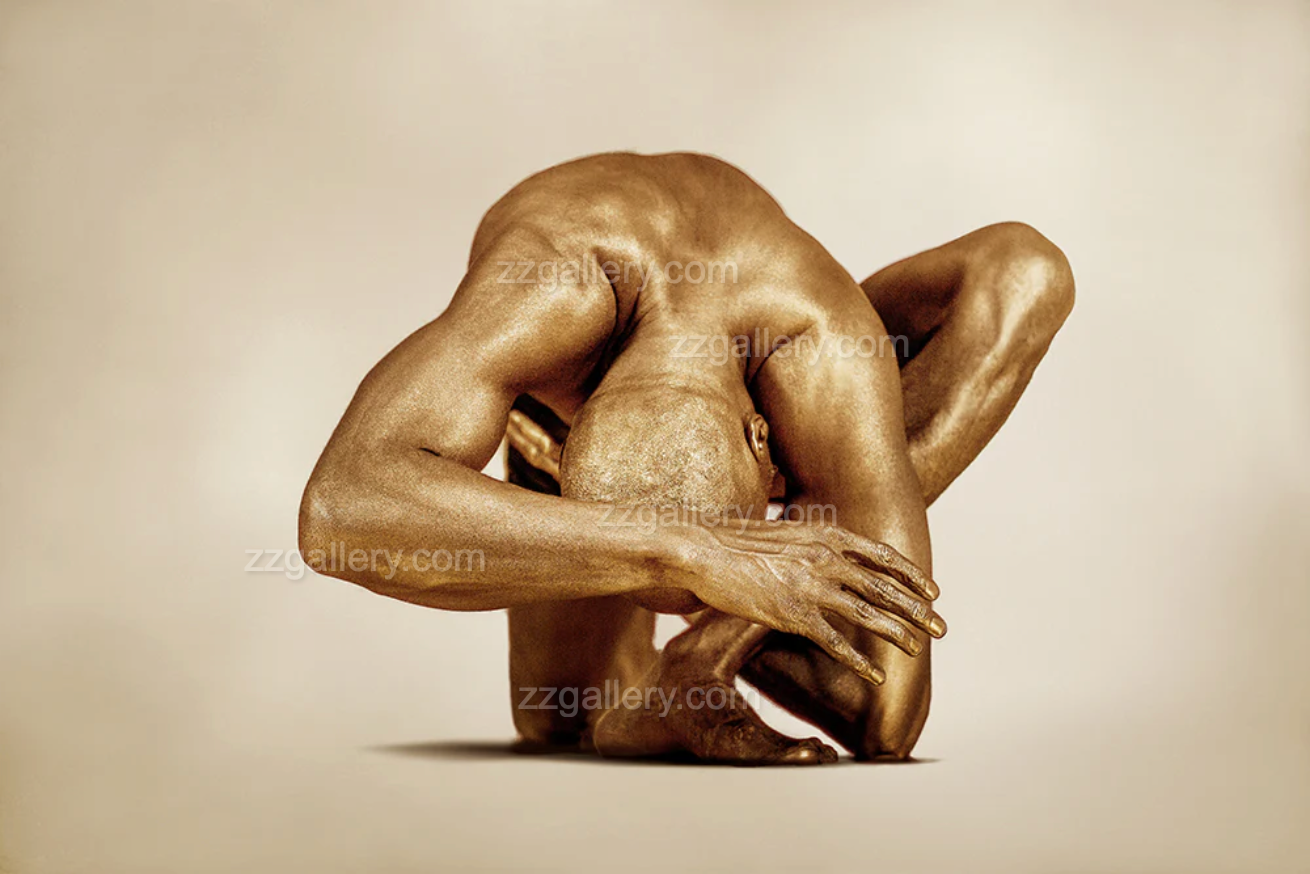 Golden male figure in sculptural fetal pose on neutral background