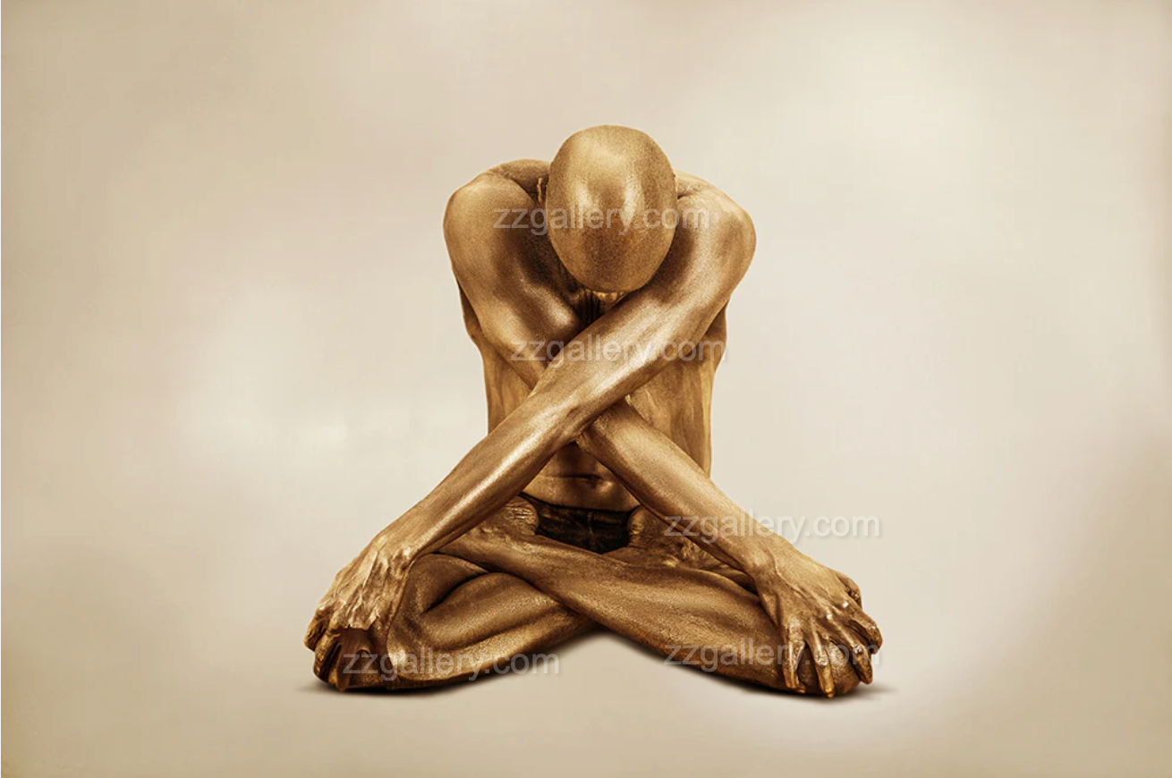 male yogi painted in gold, seated in lotus with arms crossed in deep meditation – fine art wall photography
