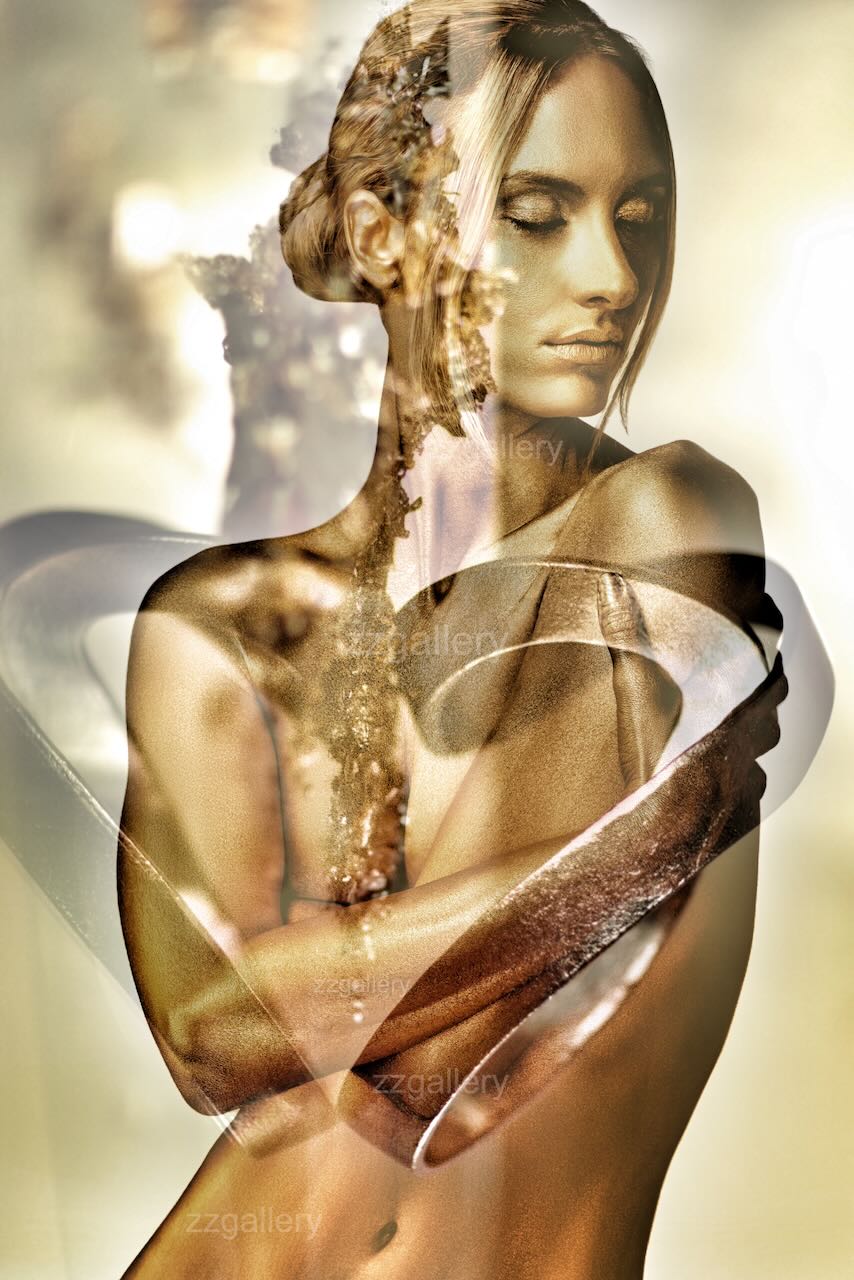 Golden-painted nude woman with closed eyes and serene expression, overlaid with luminous heart shapes and abstract textures, symbolizing divine love and inner radiance in fine art photography by Zack Zublena.
