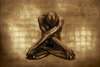 Golden-painted nude male yogi in lotus pose with arms crossed and head bowed – sacred meditation wall art photography