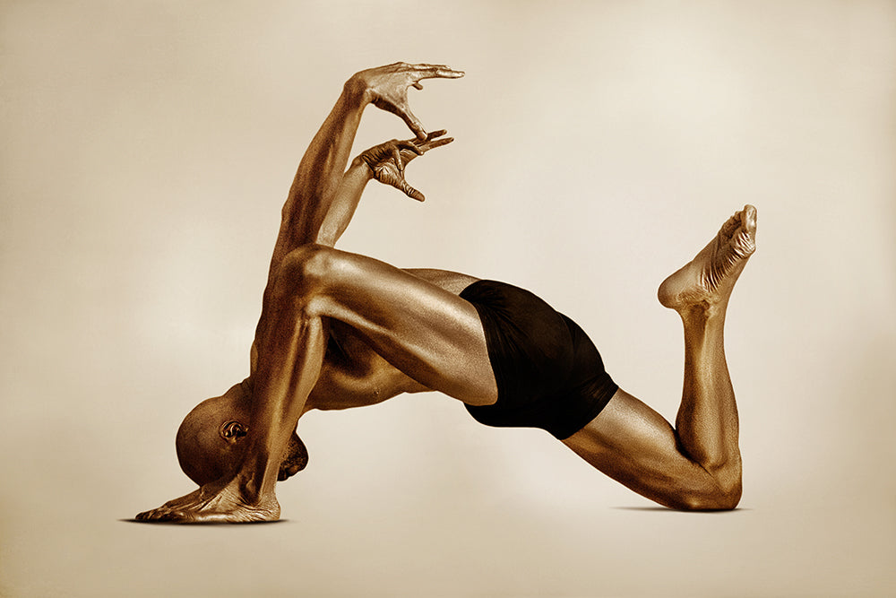 Golden sculptural figure in dynamic backbend yoga pose with angular arms and one knee lifted, symbolizing strength, balance, and geometric harmony.”