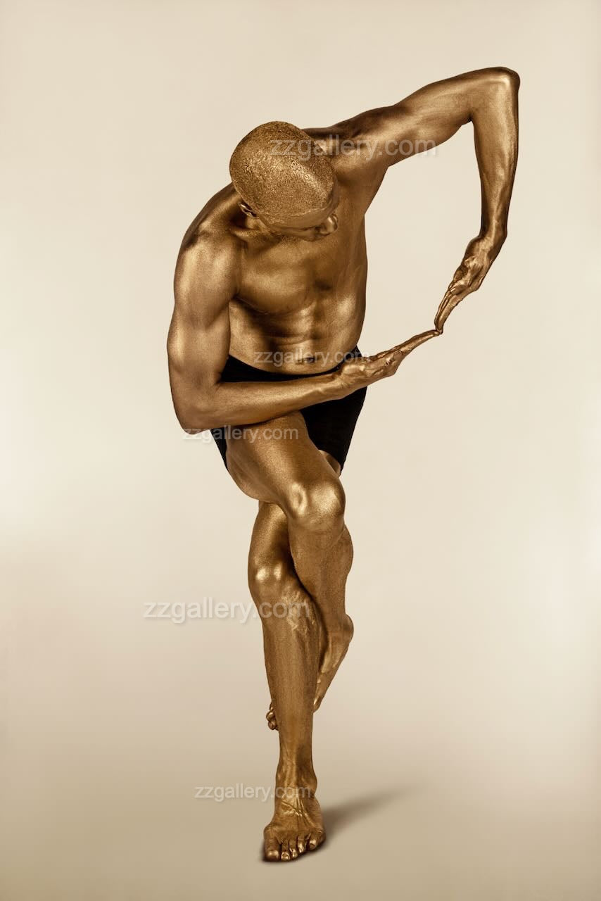 Golden-painted male figure in a dramatic yoga twist pose with elegant arm arc, luxury fine art photography displayed in a bright modern interior, ideal for yoga spaces and wellness design.